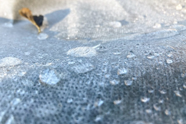 Close-up of water droplets sitting on the surface of horticultural fleece